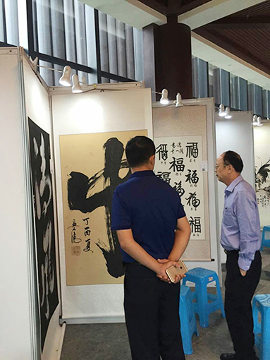 福建泉州市古建公司董事长蒋钦泉和中企报盟信息科学研究院秘书长薛雷在谭贵清老师作品前讨论.jpg
