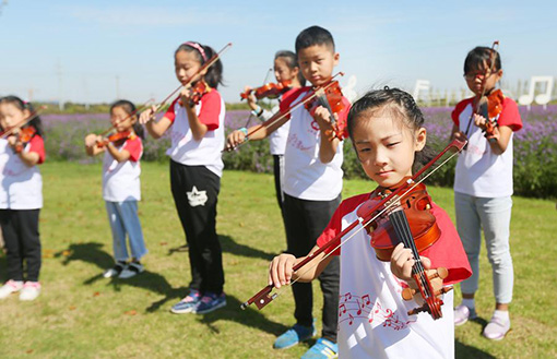 10月1日，在江苏省南通市鲜花小镇，学生们在演奏乐曲。 当日，江苏省南通市鲜花小镇举行“国庆花海音乐演奏会”，来自通州区中小学的百余名学生演奏爱国曲目，为祖国庆生.jpg